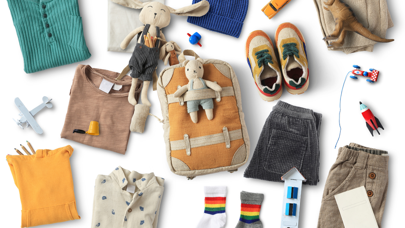 A colorful flat lay collage of various curated SnuggleBox baby and toddler products, including soft clothing, a plush bunny, small shoes, and travel-themed toys, representing a unique selection.