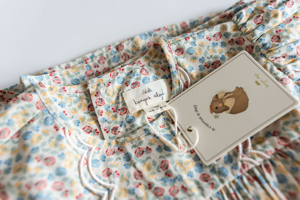 Floral-patterned fabric with a tag featuring an illustration of a bear.