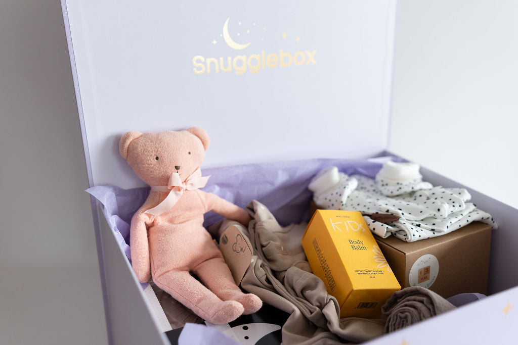 Snugaboo baby product box with a teddy bear, clothes, and a box inside.