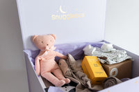 Snugaboo baby product box with a teddy bear, clothes, and a box inside.