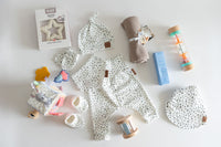 Collection of baby items including clothing, toys, and accessories on a white background