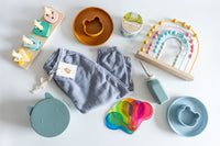 Collection of baby products including toys and clothing on a white background